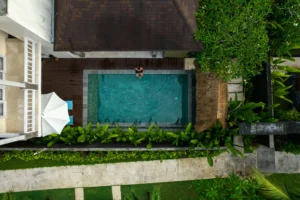 Top-down view of an affordable hotel in Bali with a private pool surrounded by tropical greenery